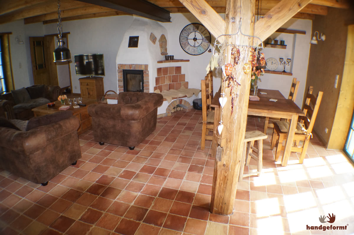 Wohn- und Essbereich mit Art Blättermann Terracottafliesen (20×20 cm). Auch am Kamin und der warmen Sitzbank sind die Fliesen verbaut worden.