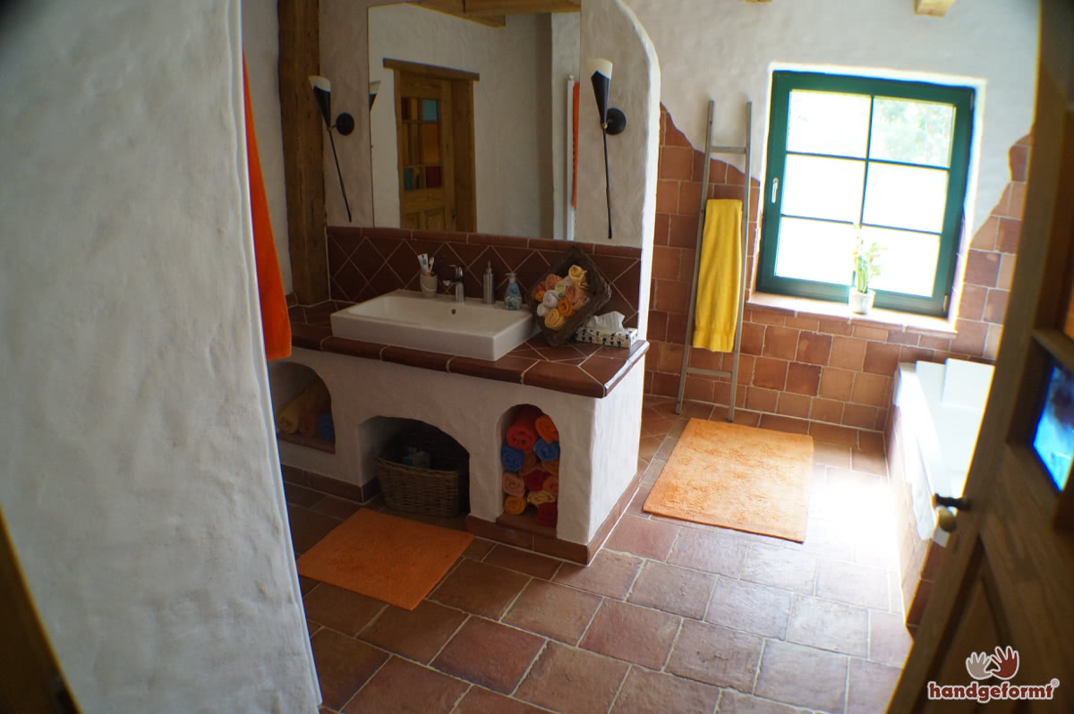 Kreativer Einsatz von Terracotta-Fliesen an Wand, Ofen und Dusche