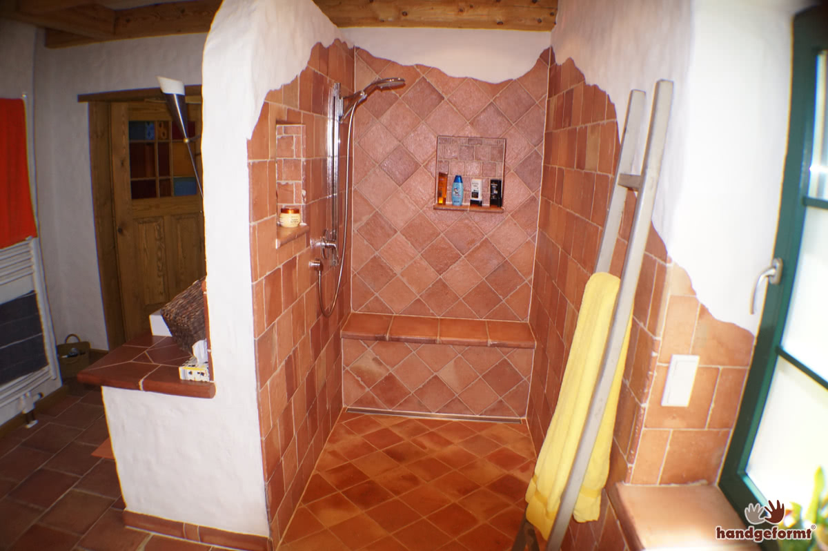 Kreativer Einsatz von Terracotta-Fliesen an Wand, Ofen und Dusche