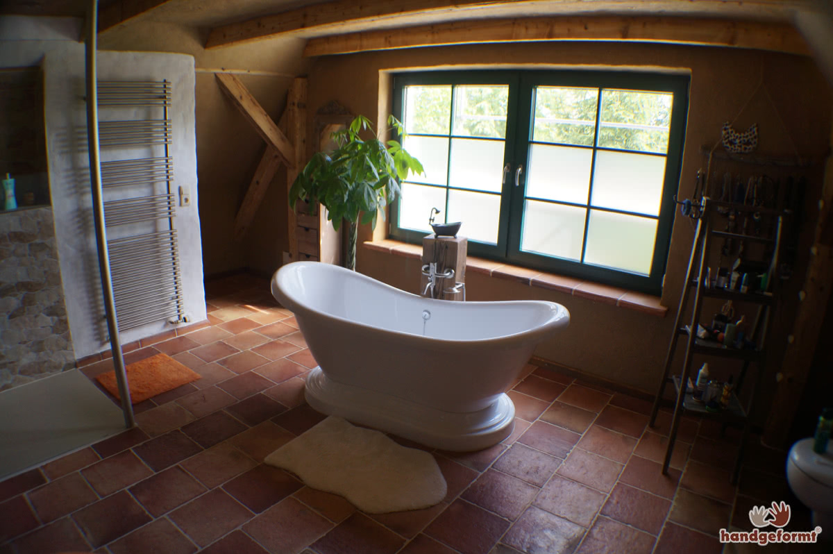 Kreativer Einsatz von Terracotta-Fliesen an Wand, Ofen und Dusche