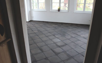 Schwarze Bodenfliesen mit Sockelleisten.